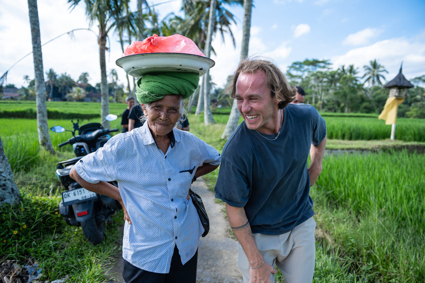 Jaro laughing with a local vendor beside a rice field