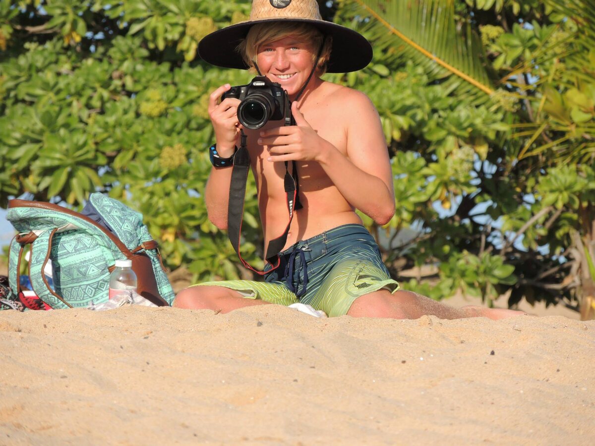 A young Jaro holding his first camera on a beach in Hawaii